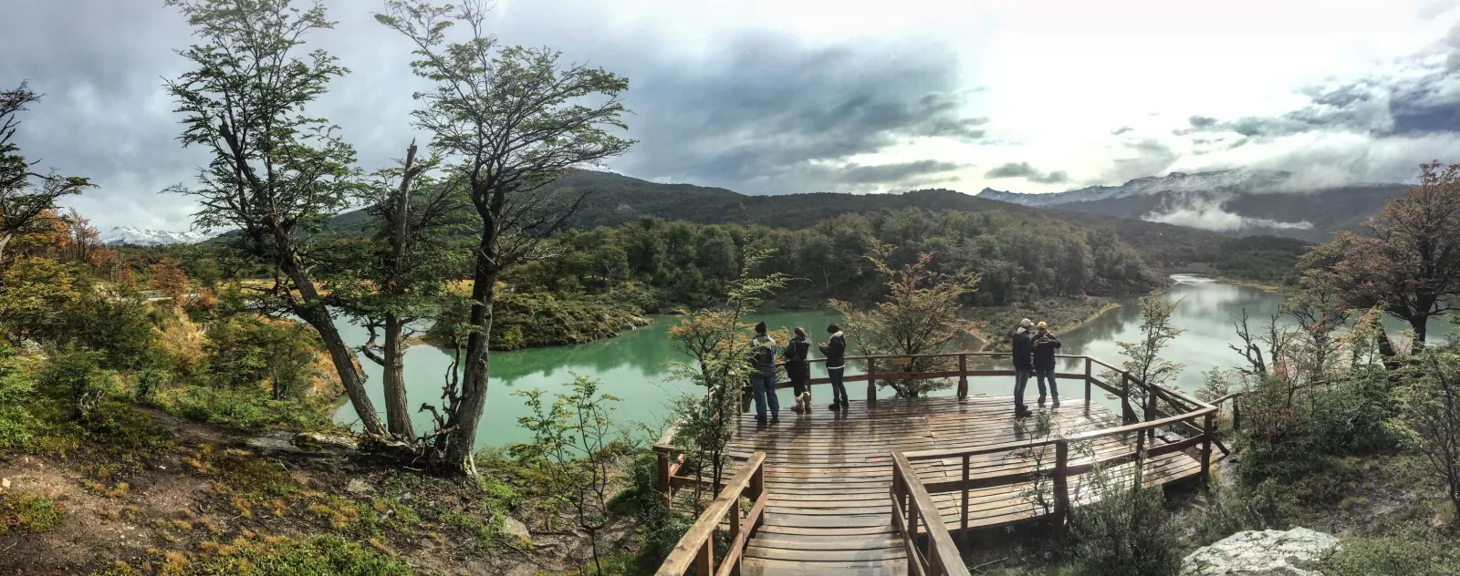 Group on a boardwalk lookout above a turquoise river
