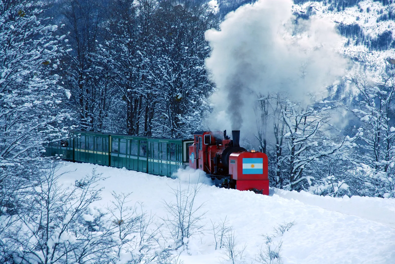 Red locomotive with an Argentine flag ploughing through snow