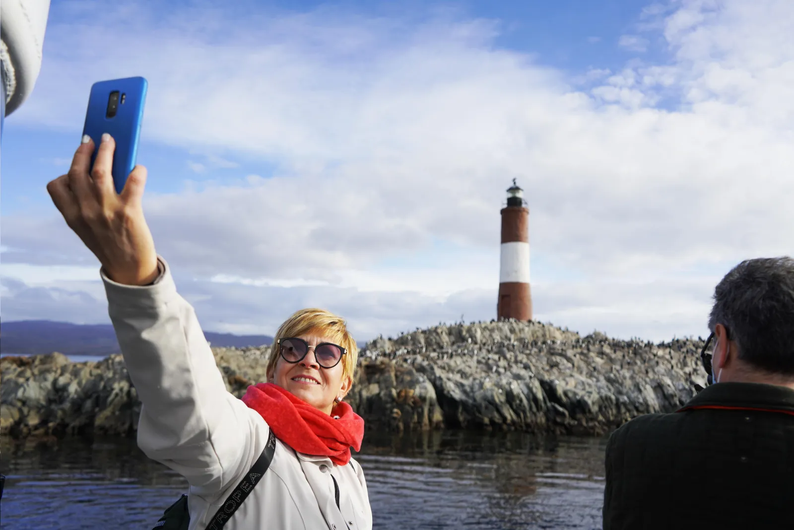 Passenger taking a selfie with Les Éclaireurs Lighthouse behind