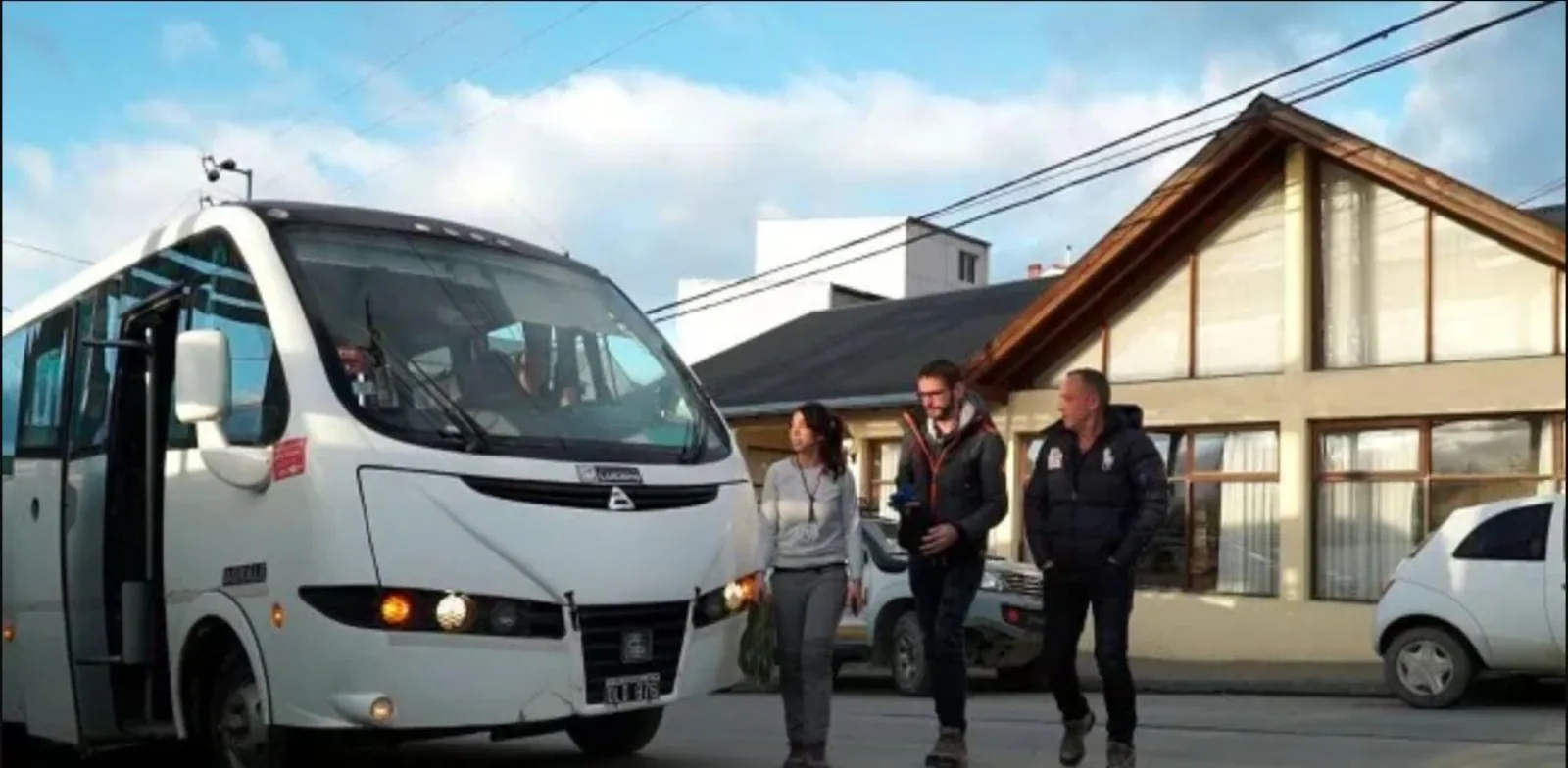 Tour minibus and passengers at a stop in Ushuaia