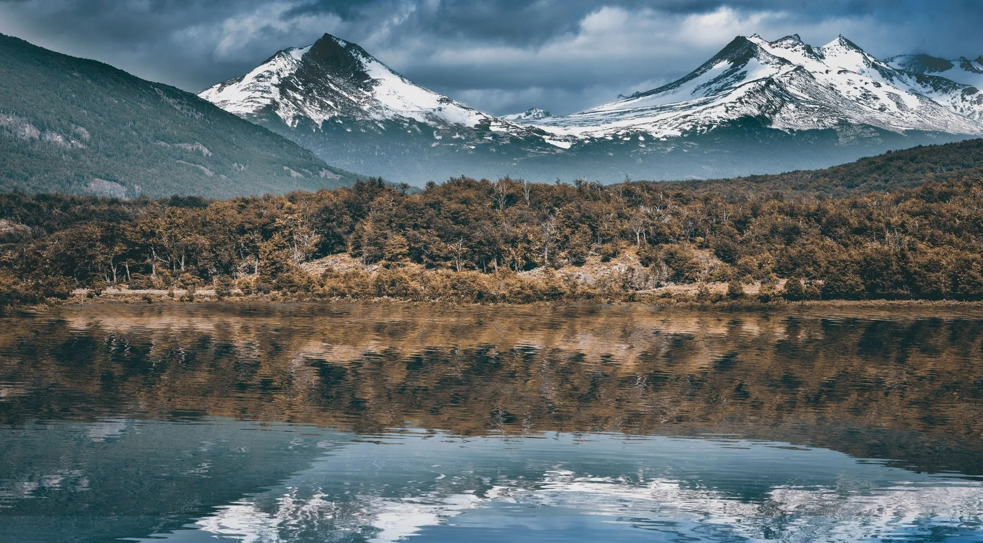 Snow-capped mountains mirrored in still water in Tierra del Fuego